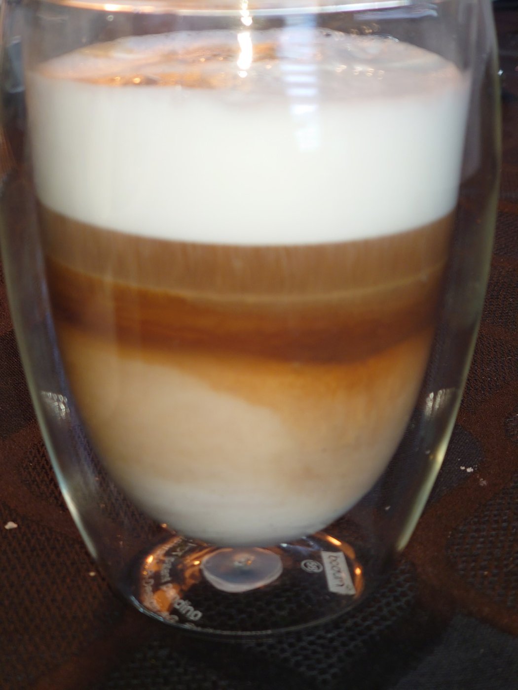 Een glas koffie met melk en een laag schuim
