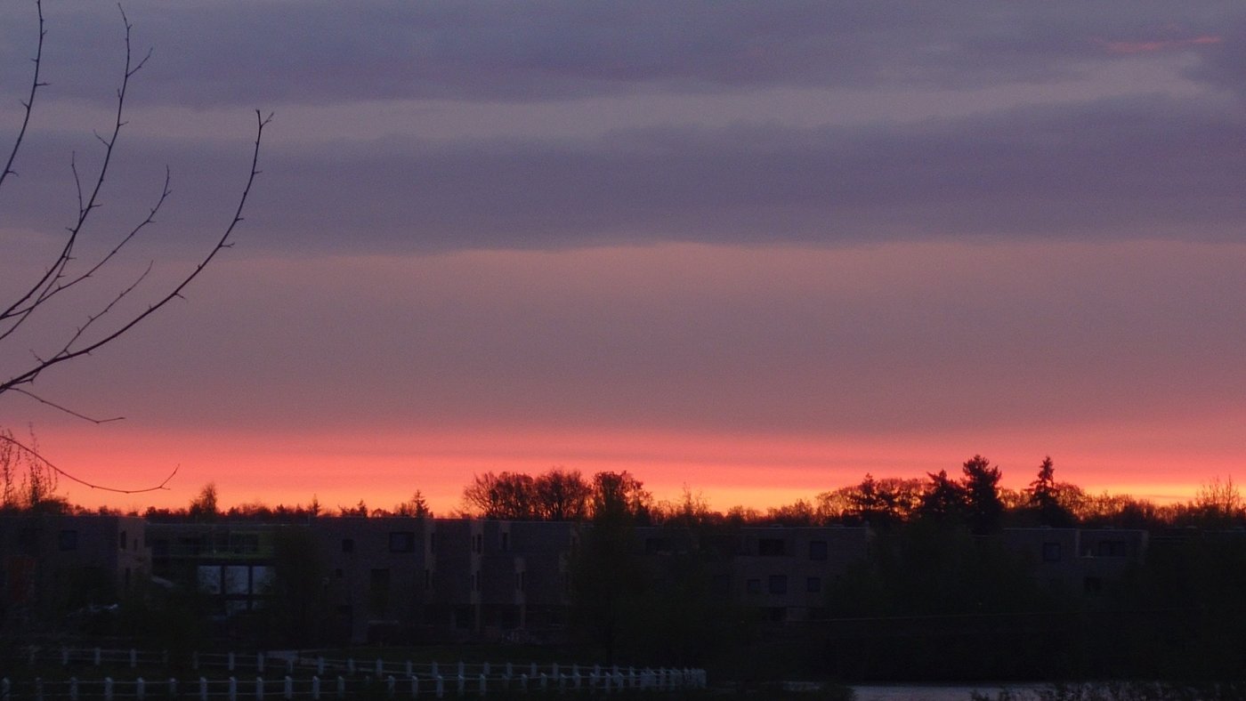 Een kleurrijke lucht boven de woonomgeving